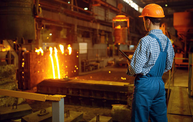 Master steelmaker in helmet at furnace with liquid metal, steel factory, metallurgical or metalworking industry, industrial manufacturing of iron production on mill