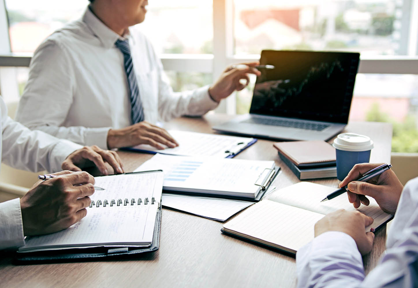 Businessman point to the laptop looking graph of the company financial statements in the computer screen and together analysis the work room 