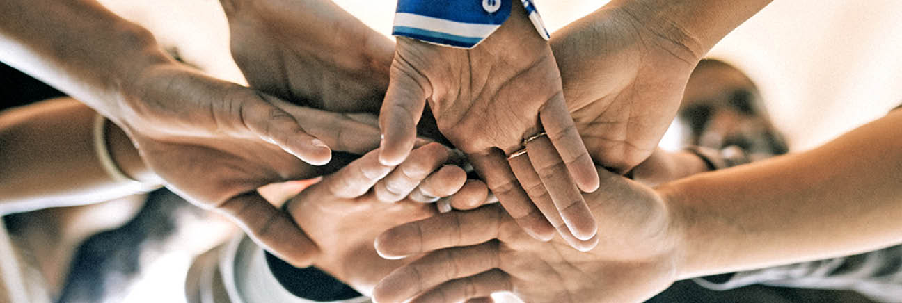 Group of diverse people stacking hands in the middle