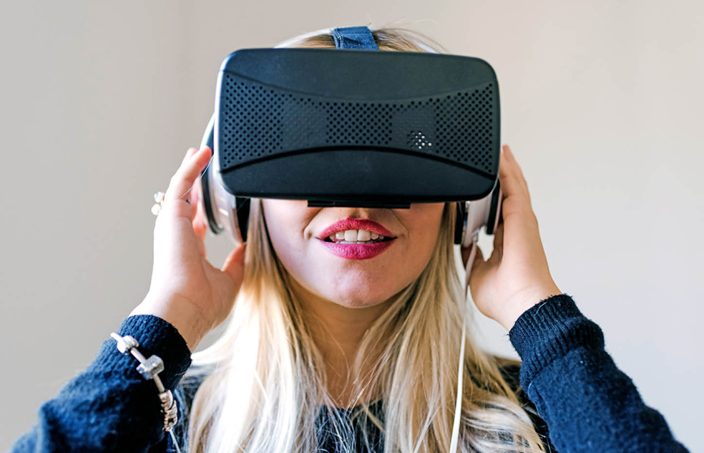 Portrait young blonde woman exploring cyberspace metaverse using 3d viewer goggles 